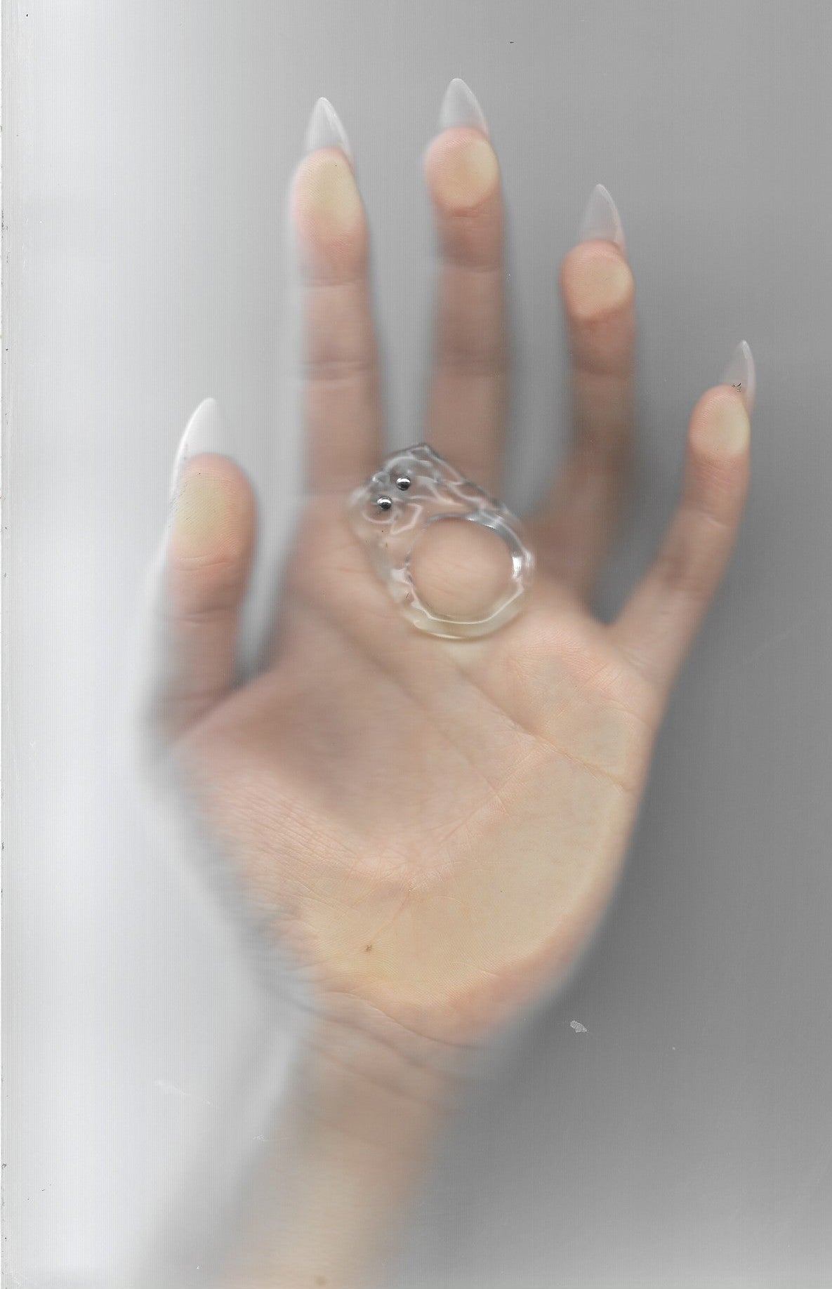 Brutalist Pierced Glass Ring 0117 in clear hand-sculpted borosilicate glass, worn on the hand, Rain and Rivers