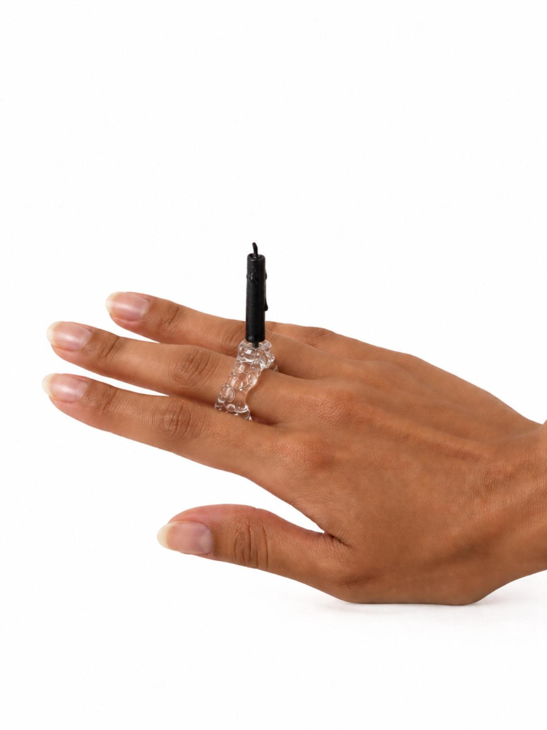 Candle and Flower Glass Ring 0136 by Rain and Rivers: a textured handmade clear glass band with a hidden steel pin holding a black taper candle, worn on the hand, on a white background