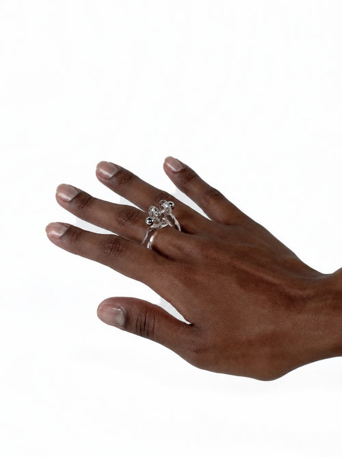 Barbell Piercing Glass Ring 0076 in clear hand-sculpted borosilicate glass with a stainless steel barbell, worn on the hand, Rain and Rivers